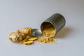 Ginger, Ground - Close-up of fresh ginger root with sliced pieces and ginger powder spilled from a metal container.