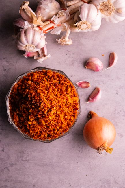 Garlic Powder - A vibrant blend of spices with garlic and onion on a rustic tabletop, perfect for culinary inspiration.
