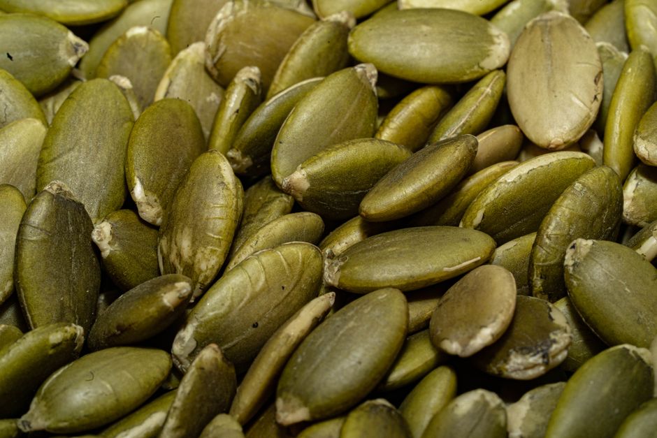 Pumpkin Seeds - A detailed macro shot of a pile of fresh green pumpkin seeds, perfect for healthy eating concepts.